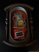 Front view of Carling Black Label plastic bar sign in faux-wood frame