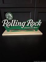 Front view of Rolling Rock plastic bar sign on base