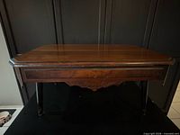 Front view of wooden table showing top, apron and legs