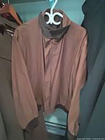 Front view of brown bomber jacket on hanger