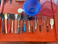 Full array of utensils laid out with bowls, strainer and measuring cups for scale