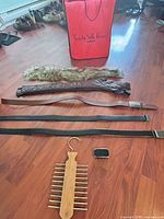 All items laid out: belts, collar, organizer, buckle and red bag in background