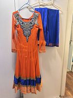 Full view of dress and matching pants on hangers