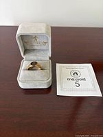 Ring in presentation box beside lot card