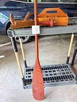 Full view of paddle, hand plane, weight, and tote on shelving