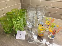 Full grouping of 6 green highballs, 5 clear goblets, 3 owl tumblers