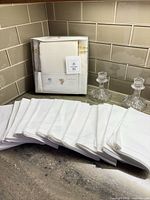 Boxed Whole Home Madison set beside stack of 12 Williams Sonoma napkins and two cut glass candlesticks