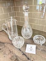 Group shot showing all glass pieces: pitcher with stir stick, decanter with stopper, rose bowl, footed bowl