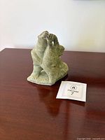 Front angled view of soapstone sculpture showing bear gripping seal