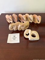 All eight stone elephant napkin rings arranged on wooden surface