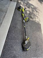 Full view of trimmer with battery inserted and charger beside