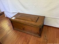 full view of wooden chest closed, showing front and side