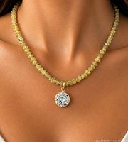 Necklace worn on model showing yellow diamond beads and moissanite pendant