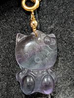 Front view of carved fluorite cat pendant showing color and shape