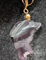 Front view of carved fluorite dolphin pendant showing color and carving detail