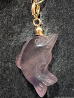 Front view of purple fluorite dolphin pendant showing carving details and bail