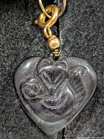 Front view of carved fluorite heart pendant showing motif and gold-tone bail