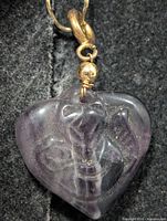 Front view of carved purple fluorite heart pendant showing color and carving detail