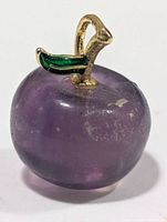 Front view showing purple fluorite apple shape, gold-tone stem bail, green enamel leaf