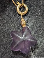 Close-up of entire pendant showing fluorite star, gold-tone bail and bead