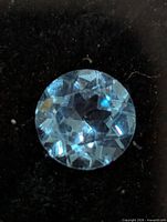 Close-up of the round faceted blue topaz gemstone