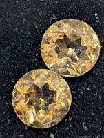 Close-up of both citrine gemstones showing facets and color
