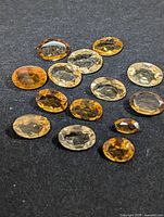 Group of loose faceted citrine gemstones on dark surface