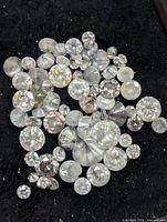 Group of loose diamonds on black background showing assorted sizes