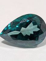 Pear-shaped green topaz profile view showing facets