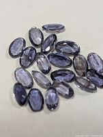 Group of faceted oval iolite stones on neutral background