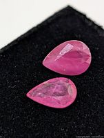 Two pear-cut rubies on black background