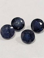Four blue round-cut sapphires close-up