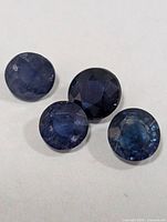 Four round blue sapphires close-up on white background