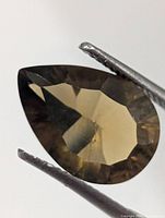 Front view of pear-cut smokey quartz in tweezers