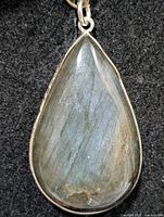 Front view of pear-shaped labradorite pendant with silver frame and bail