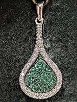 front view of teardrop pendant showing clear and green CZ setting