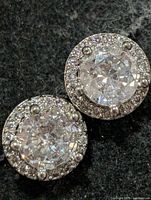 Front view of both earrings displaying CZ centres and halo