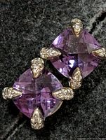 Front view showing cushion-cut amethyst stones and CZ-tipped prongs