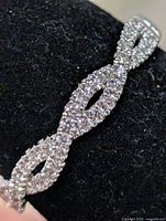 Top view of silver CZ ring showing infinity twist design
