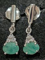 Front view showing emeralds, clear stones, silver setting