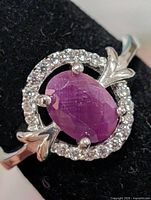front view of ring showing ruby center, CZ halo, leaf shoulders