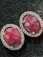 Front view showing oval dyed ruby centers with clear stone halo