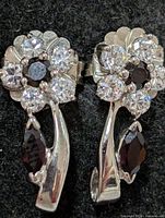 front view of earrings showing floral cluster and marquise garnet drops