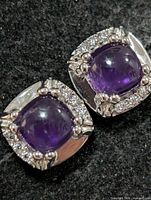 Front view of both earrings showing amethyst centers and CZ halo