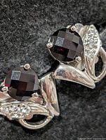 front view of both earrings showing garnets and leaf design