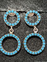 front view showing turquoise-set circular drops on both earrings