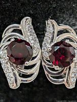 Front view of both earrings showing garnet centres and CZ accents