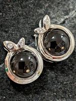 Front view of both earrings showing smokey quartz cabochons and leaf accents with clear stones