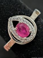 Front view showing ruby, CZ halo, teardrop setting