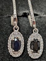 Close view of both earrings showing sapphire centres and CZ halos